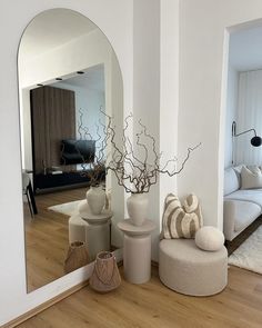 a living room filled with furniture and a large mirror