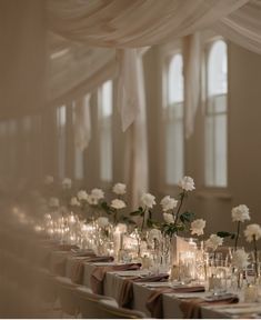 a long table with white flowers and candles