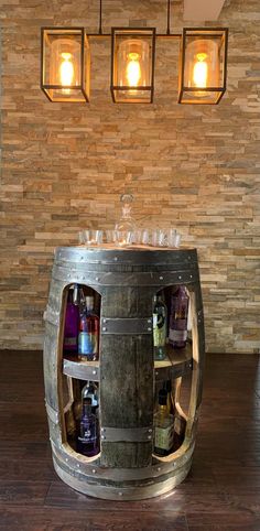 a metal barrel with bottles in it and three lights hanging from the wall behind it