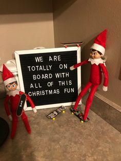 two elfs standing next to a sign that says we are totally on board with all of this christmas fun