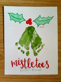 a handprinted christmas card with holly leaves and mistletoes