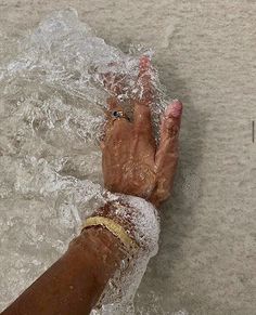 a person's hand in the water with their fingers extended out to catch something