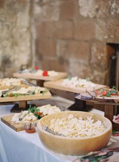 a table topped with lots of different types of food on top of wooden trays