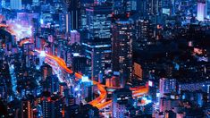 an aerial view of a city at night with bright lights and skyscrapers in the background