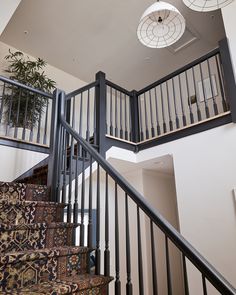 a stair case in a home with carpet and rugs on the floor below it