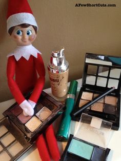 an elf sitting on top of a table next to makeup