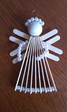 a white angel ornament sitting on top of a wooden table next to a pair of scissors