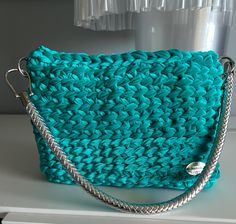 Shoulder bag in light blue/turquoise velvet ribbon. Magnetic closure, shoulder strap (adjustable) in silver-colored braided effect imitation leather. Taffeta lining, internal pocket Compact workmanship that makes the bag solid but light. Shiny and bright effect, a chic touch for every occasion. The small size makes it suitable for both day and evening. 27 x 6 x 18.5 cm (h) One of a kind piece Turquoise Rectangular Shoulder Bag For Evening, Turquoise Rectangular Evening Shoulder Bag, Velvet Ribbon, Blue Turquoise, Turquoise Blue, Magnetic Closure, Purses And Handbags, Silver Color, Shoulder Strap