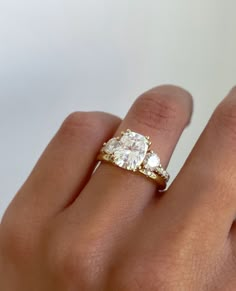 a woman's hand with a ring on it and a diamond in the middle