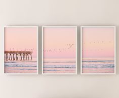 three framed pictures hanging on the wall above a couch in front of an ocean view