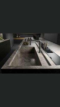 a modern kitchen with an island sink and countertop is shown in this image, it appears to be very dark