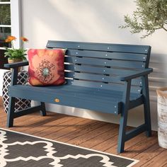 a blue bench sitting on top of a wooden floor next to a potted plant