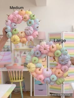 a person holding up a wreath made out of fake doughnuts and cotton balls