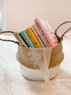 a basket filled with books sitting on top of a white tablecloth covered table cloth