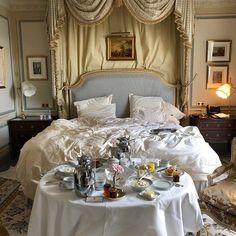 a bed sitting in a bedroom next to a table with food on top of it