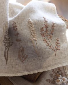 two pieces of linen with embroidered designs on them