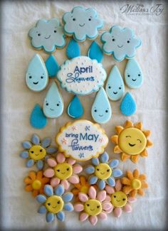 some cookies that are on top of a white table cloth with blue and yellow icing