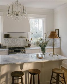 a kitchen with marble counter tops and stools