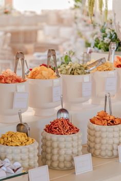 an assortment of different types of food on display at a wedding or reception table with place cards