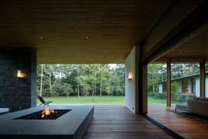 a fire pit sitting on top of a wooden floor next to a living room filled with furniture