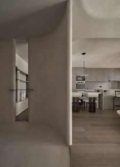 an empty kitchen and dining room are seen in this image from the hallway to the living room