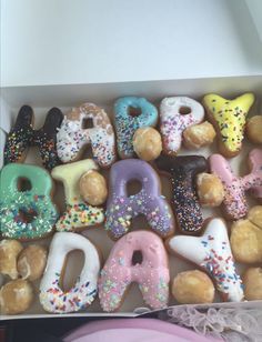 a box filled with lots of donuts covered in sprinkles and frosting