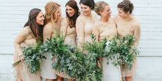 a group of women standing next to each other in front of a white brick wall