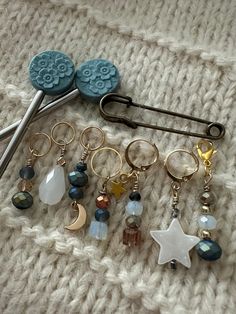 the knitting needles are next to some charms