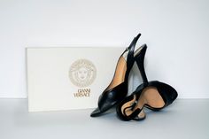 Classic and modern, these Versace slingbacks haven’t aged a day. The heels themselves are minimalist, focusing on elegant cuts and shapes and are accented with a tiny silver Medusa on the ankle strap. In beautiful condition, minimal scratching or wear on the leather. Slight greening on the metal and noticeable wear is the soles. The best part - they come with the original shoe box and dust bag from the 90’s!Condition: GreatComposition: LeatherSize: EU 36Additions: Shoe box, dust bag Black Slingback Heels, Vintage Versace, Slingback Heels, Slingbacks, Slingback Heel, Shoe Box, Womens Heels, Ankle Strap, Versace