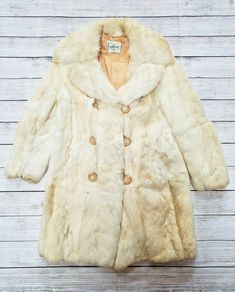 1950s KAPLAN'S CHICAGO TRUE VINTAGE FOX FUR CREAM WARM COAT MEDIUM MD. Shipped with USPS Priority Mail. 1950s Kaplan's Chicago Fox (?) Tan Fur Coat, not 100% sure if it's fur, but it's a fur Fully lined, the lining has loose stitching on inside right bottom (as shown). Bakelite buttons with elastic closure. Some wear by second button (as shown). Small discoloration on bottom left (as shown) and bottom back right (as shown). Slight dinginess at wrists (as shown). Please ask if you have any questi Vintage Cream Fur Coat For Winter, Cream Vintage Fur Coat For Winter, Vintage Cream Outerwear With Button Closure, Vintage White Winter Outerwear, Vintage Winter Outerwear, 1970s Winter Outerwear With Buttons, Fox Tan, Bakelite Buttons, Vintage Fox