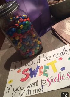 a jar full of candy next to a sign that says it would be really sweet if you went to the studio with me