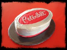 a red and white cake sitting on top of a black plate next to a red table