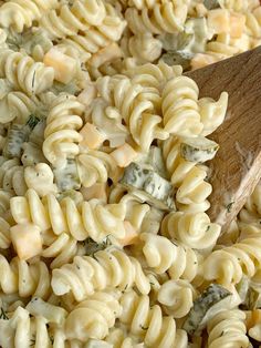 a wooden spoon is in a pasta salad