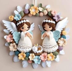 a crocheted wreath with two angel figurines