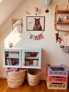 two baskets sit next to each other in front of a wall with pictures on it