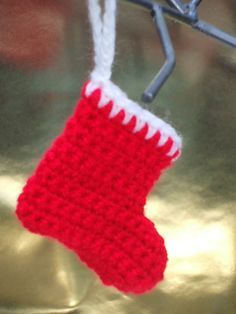 a red and white knitted stocking hanging from a hook