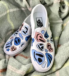 Multicolored smiley faces painted in acrylic paint and sealed against water damage. Trippy Shoes Art, Diy Vans Shoes Paint, White Canvas Shoes Painting, Things To Paint On Shoes Easy, Diy White Vans Design, Vans Shoes Custom Ideas, Hand Painted Vans Slip On, Shoe Drawing Ideas Vans, Vans Costumized Ideas