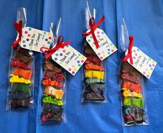 three bags filled with different types of toy cars on top of a blue cloth covered table