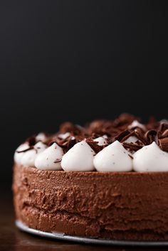 a chocolate cake topped with whipped cream and chocolate shavings