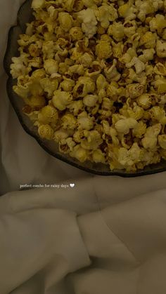 a bowl filled with popcorn sitting on top of a white cloth covered tablecloths