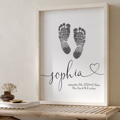 a baby's hand and foot print in a white frame