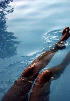 a person floating in the water with their feet up