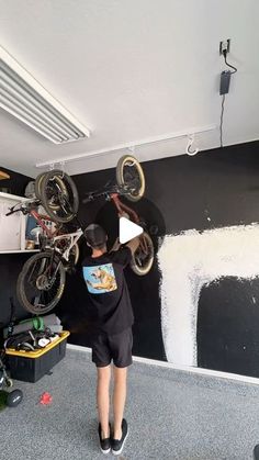 a person on a bike doing tricks in a room with black and white wallpaper