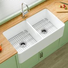 two white kitchen sinks sitting next to each other on top of a wooden countertop