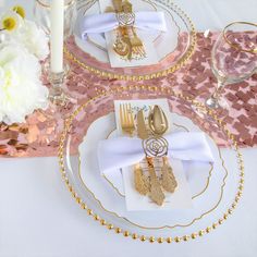 a table set with gold and white place settings