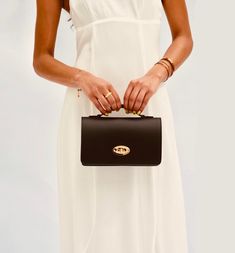 The Amelia Bag is set to be your favourite plus one. The perfect size for carrying all your essentials, making it your go-to bag for those special events. Made in Italy from smooth ruga leather, the bag is fully lined and features iconic gold detailing with a twist lock clasp and an internal zip pocket.   Carry yours by the top handle or attach the crossbody chain to go hands-free.  The stylish bag is delivered in a branded dust bag and includes a detachable gold crossbody chain strap. Wipe clea Luxury Clutch Shoulder Bag For On-the-go, Elegant Shoulder Flap Bag For On-the-go, Classic Top Handle Box Bag For On-the-go, Chic Briefcase With Detachable Strap For On-the-go, Elegant Shoulder Bag With Gold-tone Hardware For On-the-go, Elegant Flap Bag With Detachable Strap For On-the-go, Luxury Top Handle Box Bag For On-the-go, Luxury Box Bag With Top Handle For On-the-go, Elegant Box Bag With Top Carry Handle For On-the-go