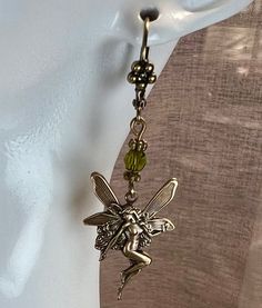 Antiqued brass fairy earrings with 4 mm olive crystal beads. These dainty little earrings approximately 2 inches long.  All purchases come in a gift box or gift bag. Handmade Elven Earrings For Gift, Whimsical Brass Dangle Earrings, Handmade Gold Elven Jewelry, Handmade Elven Gold Jewelry, Fairycore Gold Dangle Jewelry, Handmade Gold Fantasy Earrings, Gold Fantasy Handmade Earrings, Gold Handmade Fantasy Earrings, Green Fairy Earrings For Gift