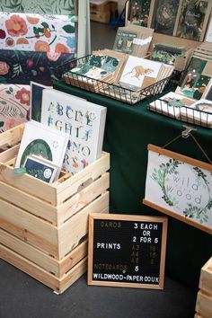 several wooden boxes with greeting cards on display at an outdoor market stall in the uk