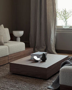 a living room with two couches and a coffee table in front of a window