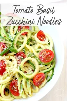 a white bowl filled with zucchini noodles and tomatoes